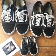 four pairs of black and white shoes are on the floor next to an old photo