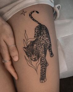 a woman's thigh with a tattoo of a leopard on it