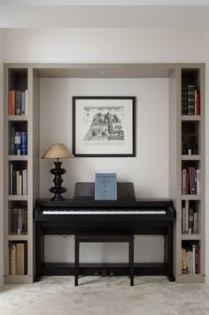 there is a black piano in the corner of this room with bookshelves and a lamp