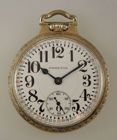 "This is classic American Railroad pocket watch made by the Hamilton Watch Co. The watch is in particularly fine condition and has the additional bonus of an Elinvar balance indicated by the prefix E in the title Movement - this high grade ¾ plate nickel movement has a lever escapement with a micrometer regulator and a gold capped escape wheel. The movement also has gold train wheels, raised gold jewel settings and is decorated with striped damascening. The movement is signed \"Hamilton Watch Co