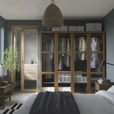 a bedroom with blue walls and white bedding has an open closet in the corner