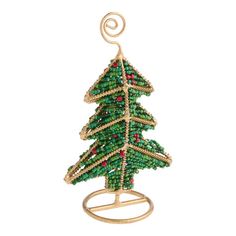 a beaded christmas tree ornament hanging from a metal holder on a white background