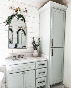 a bathroom with two sinks and a large mirror on the wall above it's cabinets