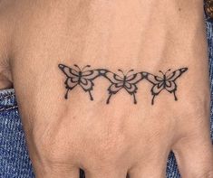 a woman's hand with three butterflies tattooed on the left side of her wrist