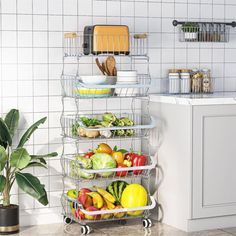 a kitchen with white tiled walls and flooring has a metal rack holding fruits and vegetables