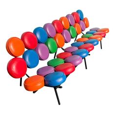 a row of colorful seats sitting next to each other on top of black legs and feet