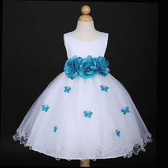 a white dress with blue flowers and butterflies on the skirt is sitting on a mannequin