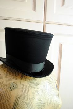 This simple and elegant victorian inspired top hat is covered in a beautiful black satin with a gentle shine .It is finished off with matching colored ribbon around the crown. Need this TOP HAT in another color? with more decoration? Just send me a message to talk about a custom hat made just for you! This hat is fully lined with satin and it is made to according to your exact head measurement making it suitable for both men and women who want a bit more on their head than a mini hat! IMPORTANT Victorian Fitted Hats For Costumes, Victorian Fitted Costume Hats, Victorian Style Fitted Costume Hats, Fitted Gothic Brimmed Top Hat, Gothic Fitted Brimmed Top Hat, Fitted Brimmed Top Hat For Costume Party, Steampunk Fitted Top Hat For Costume, Fitted Top Hat With Curved Brim For Costume, Fitted Top Hat With Short Brim For Costume Party