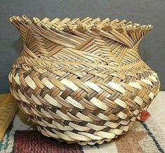 a large woven basket sitting on top of a rug next to a ruler and measuring tape