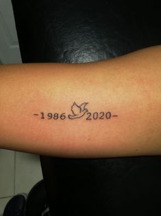 a person with a tattoo on their arm that reads, year 1960 - 2006 and has a bird