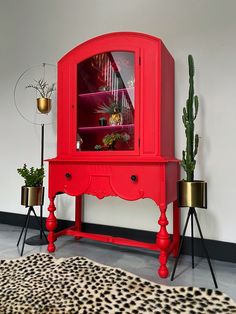 a red cabinet sitting next to a leopard print rug