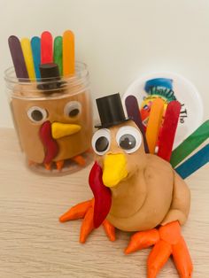 two plastic turkeys are sitting next to each other on a table with markers in their beaks