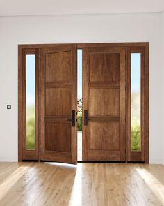 an empty room with two wooden doors and hard wood flooring on one side, looking out onto the outside