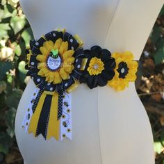 a yellow and black belt with sunflowers on the front, white polka dots around the waist