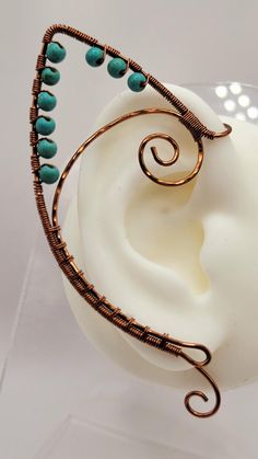 a wire wrapped earring with turquoise beads