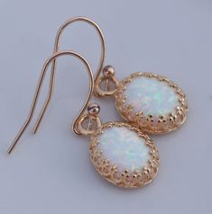 "Stunning earrings made using lab created opal gems and 14K gold filled. Each opal is white in color with colorful flashes with each turn of the stone. The opals are hand set into 14K gold plated premium crown bezel settings. They hang from 14K gold filled french earwires. Opals each measure 10mm tall (just shy of 1/2\") while entire earring length is 1\". PREFER SILVER? Just leave a note at checkout and I can gladly make in sterling silver. Made to match this necklace and bracelet: https://www. Gold Opal Cabochon Earrings, Gold Opal Drop Earrings, White Opal Jewelry With Matching Earrings, White Opal Drop Earrings, White Opal Earrings, Earring Gold, Gold Crown, Earrings Small, October Birthstone