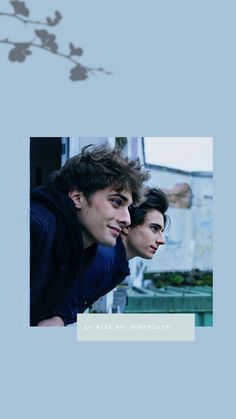 two young men sitting next to each other in front of a blue background with flowers