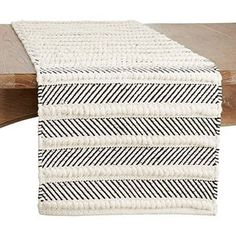 a white and black table runner on top of a wooden table