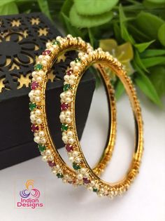 A pair of Extreme high quality gold plated pearl bangle with tiny round ruby and emerald stone work and in unique designs. Elegant Multicolor Bangle For Celebration, Elegant Multicolor Beaded Bracelets For Festive Occasions, Gold Bangle Pearl Bracelet In Temple Jewelry Style, Gold Temple Jewelry Pearl Bangle Bracelet, Gold Temple Jewelry Pearl Bangle, Elegant Multicolor Pearl Bracelets, Traditional Pearl Bracelets As A Gift, Traditional Pearl Bracelets For Gifts, Elegant Multicolor Beaded Bracelets For Wedding