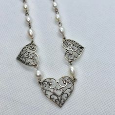 This Vintage Sterling Silver Heart and Pearl Necklace is beautiful. It's in very good condition it's adjustable it has 3 Hearts with the Center Heart being the largest and 1 Heart on either side. Very delicate and ornate design for the silver Hearts and beautiful pearls Great as Bridal Jewelry Elegant Silver Necklace For Special Day, Ornate Heart Charm Jewelry For Weddings, Vintage Sterling Silver Heart Necklace For Wedding, Ornate Heart Charm Wedding Jewelry, Vintage Open Heart Necklace For Wedding, Silver Adjustable Heart Necklace For Wedding, Heart Pendant Jewelry With Intricate Design For Wedding, Adjustable Silver Heart Necklace For Wedding, Ornate Wedding Jewelry With Heart Charm