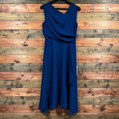 a blue dress hanging on a wooden wall