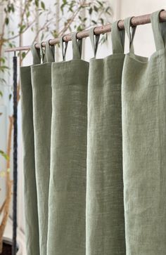 green linen curtains hanging in front of a window