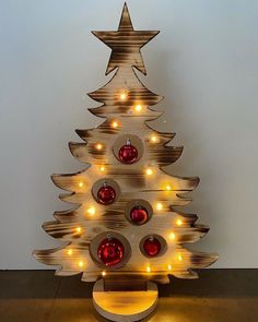 a wooden christmas tree with lights around it