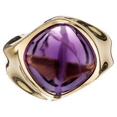 A wonderful vintage 1980's, 18k yellow gold, 8.00 carat cabochon amethyst bezel ring. The ring features an intricate twist design on the shank that adds a modern aspect to the classic beauty of the amethyst gemstone. The rich purple hue of the amethyst combined with the warm radiance of the deep yellow gold creates a striking contrast that is sure to captivate. 1 cabochon purple amethyst, approx. 8.00cts Size 7 and sizable 18k yellow gold Stamped: 750 15.0 grams Width at top: 17.5mm Height at top: 11.1mm Width at bottom: 5.2mm Please Note, we photograph each item as accurately as possible. However due to monitor/mobile device resolution and calibration, we understand some photos may vary in appearance. If you are not satisfied and offer a 30 day full money back return policy. Follow us on Luxury Yellow Gold Amethyst Cabochon Ring, Tri Color Ring, Emerald Cut Aquamarine Ring, Amethyst Cocktail Ring, Yellow Gold Cocktail Ring, Deep Yellow, Vintage Style Rings, Gold Cocktail Ring, Rich Purple