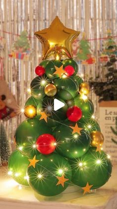 a christmas tree made out of balloons with lights and stars on the top is shown