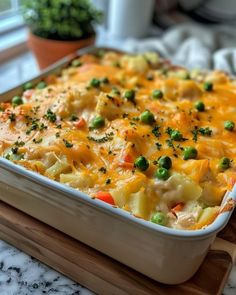 a casserole dish with peas, carrots and cheese