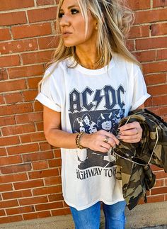 We're "livin' easy and lovin' free" with AC/DC! This vintage style rock tee is designed with black and white graphics from AC/DC's fifth studio album, "Highway To Hell". Made with soft cotton fabric, a ribbed crew neckline, short sleeves, and a classic oversized t-shirt fit. Trendy Band Logo T-shirt For Concerts, Retro T-shirt For Everyday Fall Wear, Casual Cotton T-shirt For Concert, Casual Graphic Print T-shirt For Concerts, Trendy Summer Concert T-shirt, Trendy T-shirt For Summer Concert, Trendy Summer T-shirt For Concert, Grunge Graphic Print Top For Music Festival, Trendy Graphic Print Tops For Music Festival