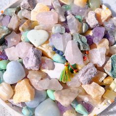 a bowl filled with lots of different colored rocks and stones on top of a table