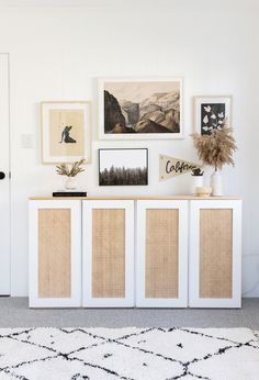 a living room with pictures on the wall and an area rug in front of it