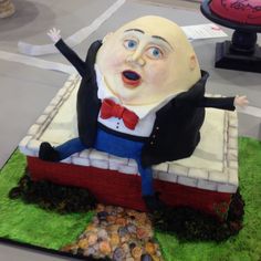 a cake made to look like a man in a tuxedo sitting on top of a brick wall