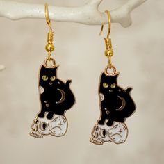 Make a statement with these spooky black cat sitting on a skull drop earrings for women. These cool quirky gold plated and enamel Halloween cat earrings are a great way to add a nice touch to your outfit. The charm on these cat on skull dangle earrings measures at 2.5cm x 1.5cm and is attached to a gold plated hook. Please feel free to get in touch with us at Funky Earrings UK if you have any questions. We also have a wide range of other cute and unusual earrings in our shop. Black Cat Sitting, Spooky Black, Halloween Black Cat, Funky Earrings, Unusual Earrings, Halloween Black, Skull Earrings, Black Cat Halloween, Cat Sitting