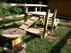 a wooden bench and table in the grass