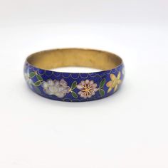 Pretty vintage cloisonne bangle bracelet. The bracelet features a lovely dark blue enamel with a floral design.   Unknown maker. Not marked. c 1970s Condition is excellent.  There are no dents or dings.  No chips or cracks.  No repairs.  No corrosion.  Ready to wear. The bracelet measures Pretty Rings, Bangle Bracelet, Bangle Bracelets, Dark Blue, Jewelry Bracelets, Floral Design, Ready To Wear, Bangles, Chips