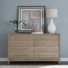 a wooden dresser sitting next to a white lamp