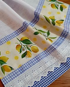 two pieces of fabric with lemons on them sitting on top of a wooden table