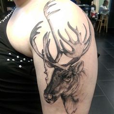 a woman with a deer head tattoo on her left arm and shoulder, in black and white