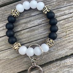 a black and white beaded bracelet with an animal print keychain on it