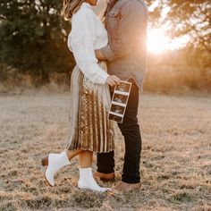 a man and woman standing next to each other in a field