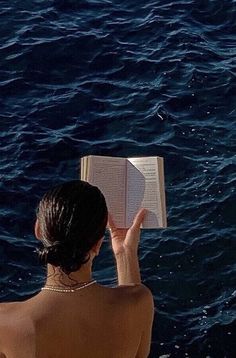 a woman is reading a book in the water