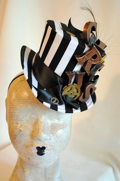 "This playful steampunk circus themed mini top hat is covered with black and white striped fabric. It is embellished with copper toned letters that spell the word \"CIRCUS\", placed vertically, over lush black satin ribbon, among some stunning and huge vintage alarm clock gears. This striking costume mini top hat wouldn't be complete without a beautiful black burnt ostrich feather. Measurements : height 4 inches( 10 cm ) front to back 9 inches ( 22 cm ) side to side 7.5 inches ( 19 cm ) This min Black Steampunk Top Hat For Alternative Fashion, Black Steampunk Costume Accessories For Themed Events, Black Punk Top Hat For Alternative Fashion, Steampunk Mini Hat With High Crown, Black Steampunk Costume Accessories For Carnival, Steampunk Black Costume Accessories For Carnival, Novelty Black Top Hat For Costume, Black Novelty Top Hat For Costume, Vintage Black Hat For Alternative Fashion