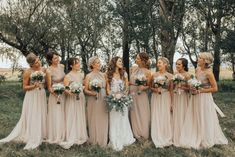 a group of women standing next to each other on top of a grass covered field