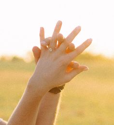 a person holding their hands up in the air with one hand on top of another