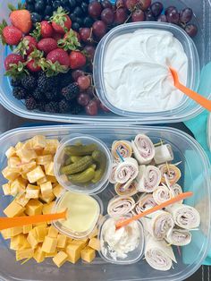 two plastic containers filled with different types of fruit and dip next to some crackers