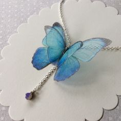 I'm in love with blue Morpho butterflies and Opals. This is a delicate and dainty creation, that celebrate my love for them. The silk organza butterfly measure about 5 cm wingspan. Silver Plated 925 chain is available in 40 cm (16 inches), 45 cm (18 inches) or more, you can choose! Closed with lobster clasp. Nickel free. The necklace pictured is long 40 cm (16 inches) and it's already sold. The pendant is a natural raw polished BLUE and GREEN Ethiopian Welo Opal that measures about 4 mm and is a Bohemian Butterfly Charm Necklace As A Gift, Bohemian Butterfly Charm Necklace For Gift, Bohemian Butterfly Necklace With Charm As Gift, Bohemian Butterfly Necklace As A Gift, Bohemian Butterfly Necklace For Gifts, Whimsical Blue Necklace For Gifts, Whimsical Blue Necklace For Gift, Blue Butterfly Necklace For Gifts, Blue Butterfly Necklace For Gift