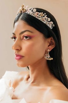 a woman wearing a tiara and earrings