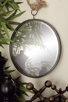 a mirror hanging on the wall next to a potted plant